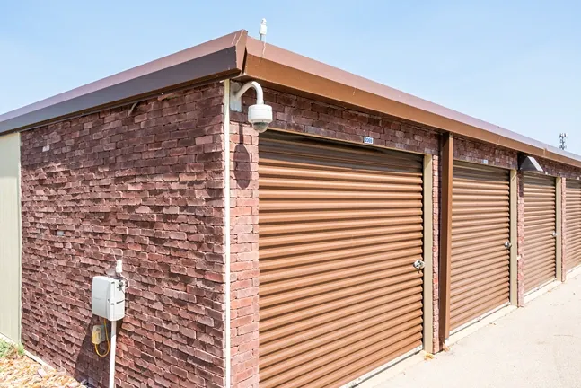 Drive-up storage unit building with security camera and individual unit access doors