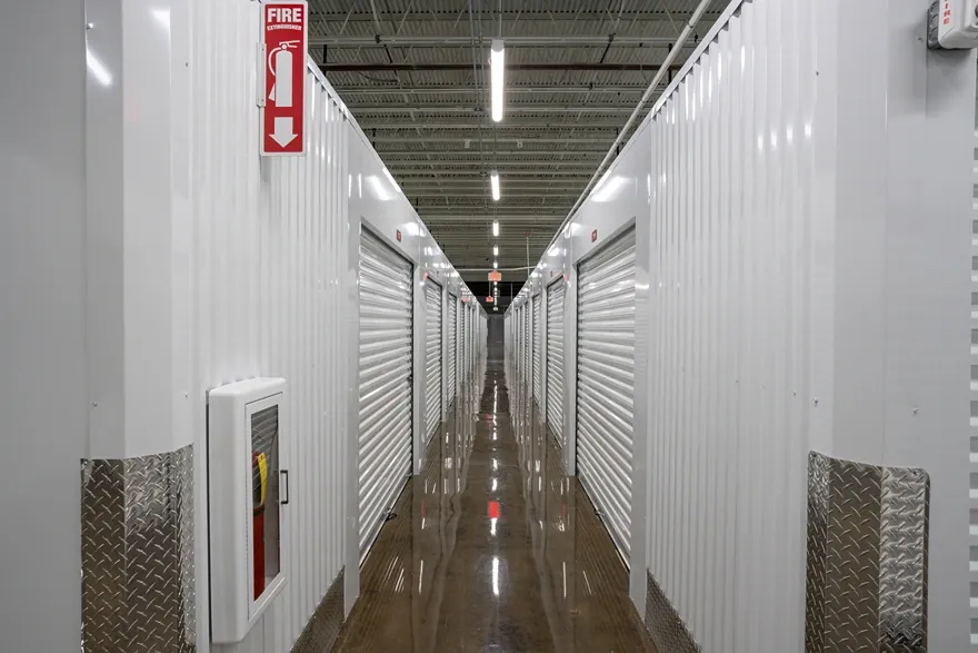 Indoor storage units with white roll-up doors and polished concrete floors