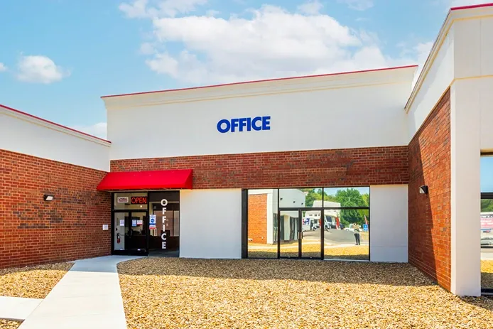 Self storage office entrance with glass doors and signage for customer service and rentals