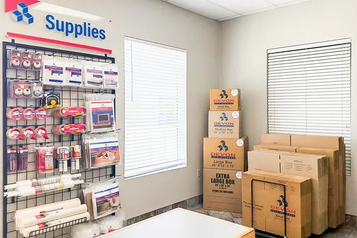 Self storage office interior with customer service desk, security monitors, and packing supplies