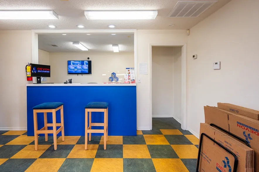 Storage facility office with customer service counter, seating, and security camera monitoring