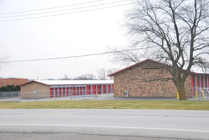Self storage facility with red doors visible from roadside location