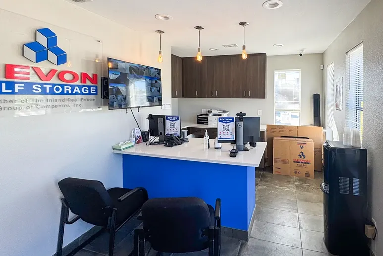 Office area with security view on the wall, plus moving, storage boxes at Devon Self Storage - Perrin in San Antonio, TX