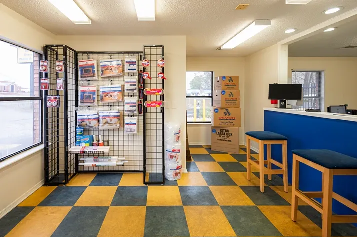 Self storage office interior with moving supplies, packing materials, and customer seating