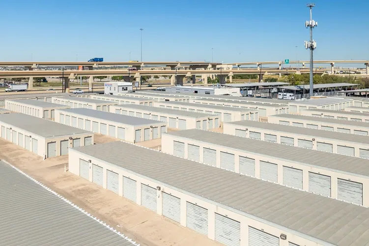 Aerial view of drive-up self storage facility near highway interchange with multiple unit rows