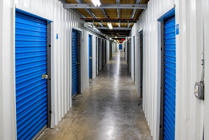 Climate-controlled indoor storage hallway with blue roll-up unit doors