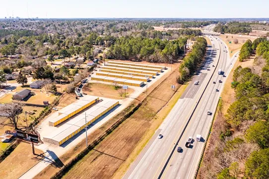 Aerial view of self storage facility located along highway with multiple rows of drive-up units