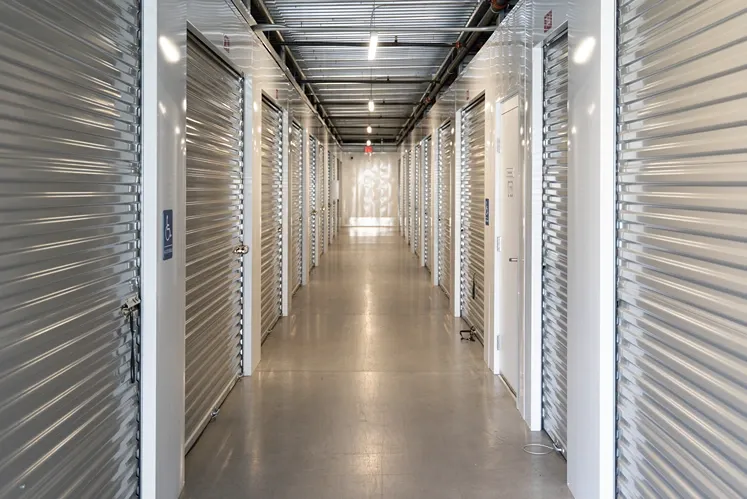 Climate-controlled indoor storage hallway with secure roll-up unit doors