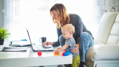 Woman and baby looking at laptop computer.