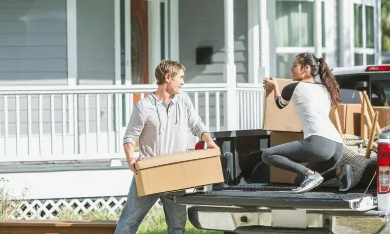 Man and woman unload boxes from pickup truck