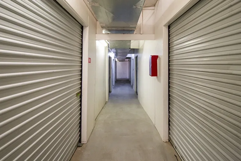 Hallway view of storage units in West Apple Valley, CA, at Devon Self Storage - West Apple Valley