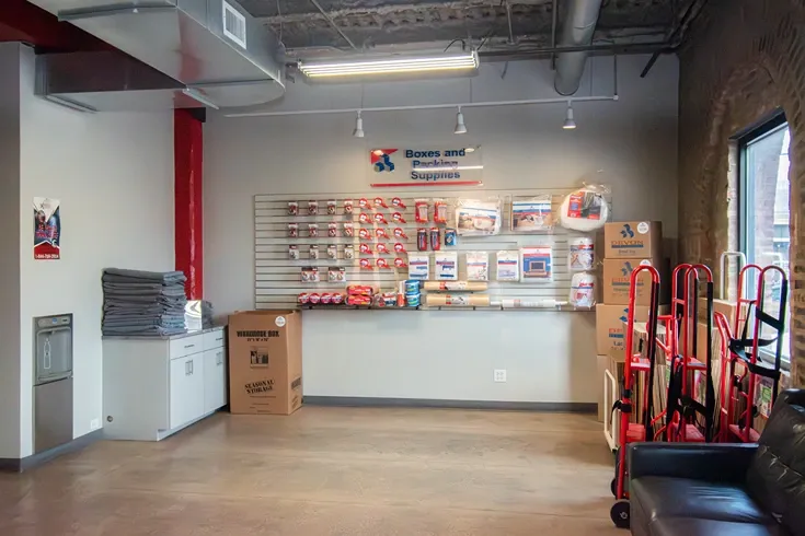 Self storage office interior with customer service desk, security monitors, and packing supplies