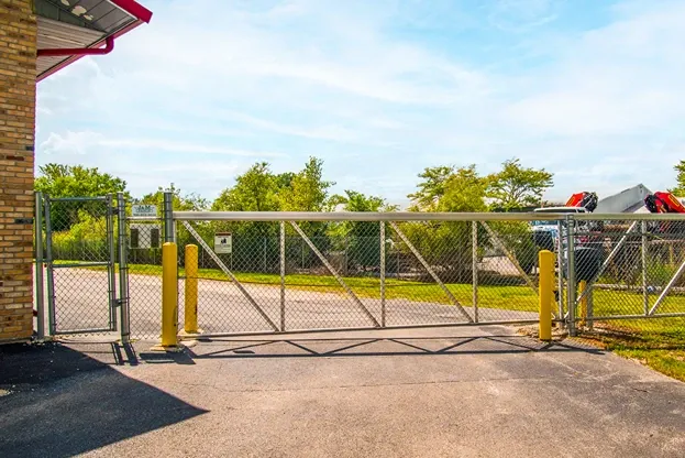 Gated self storage facility entrance with secure access and perimeter fencing