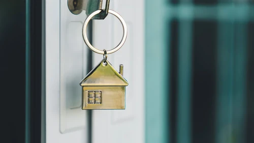 A golden key sitting in the door of someone’s newly bought home.