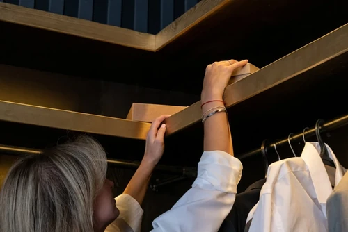 Female grabbing a jewelry box from her closet.