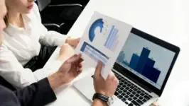 Business report and laptop in background