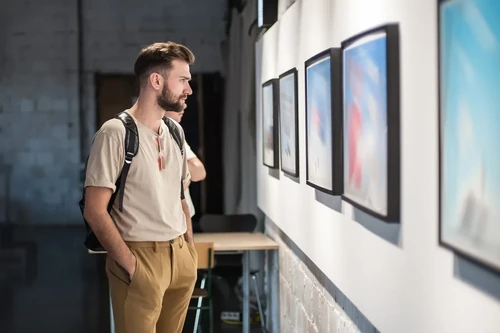 Young man looking through an art gallery at a museum.
