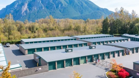 Self Storage in North Bend, WA, aerial view of storage units, outdoor, drive up, green doors. Mountain backdrop