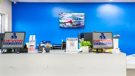 Front desk, office area with blue wall & security at Devon Self Storage Units in Raleigh, Memphis, TN