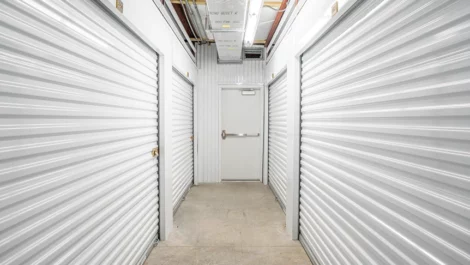 Hallway to indoor storage units, white wall and storage doors, Okeechobee Storage Unit at Devon Self Storage