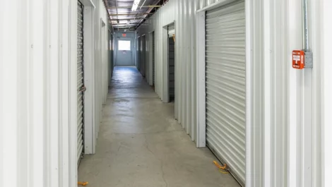 Hallway to indoor storage units. White doors, clean facility. Devon Self Storage Lowell, MA