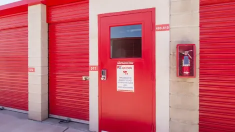 Red door entrance to storage, plus small storage unit with red doors in West Apple Valley, CA, at Devon Self Storage - West Apple Valley