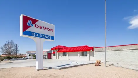 Sign of storage facility and exterior view of facility in West Apple Valley, CA, at Devon Self Storage - West Apple Valley