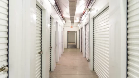 Hallway view of indoor storage units, with white doors at Devon Self Storage - St. Augustine