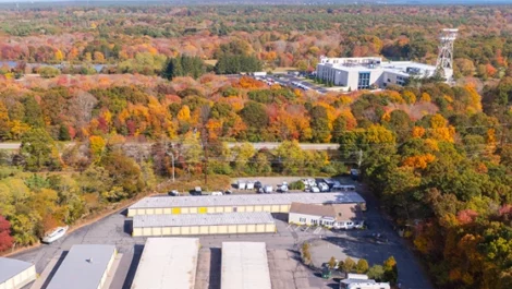 Drone view of outdoor storage units with RV/ truck parking options at Devon Self Storage - Lambeth Park in Fairhaven, MA.