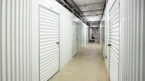 Hallways storage units with white doors. Clean, view of dollies available. Devon Self Storage - Lambeth Park in Fairhaven, MA.