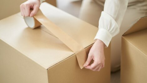 A student packing taping their boxes for storage