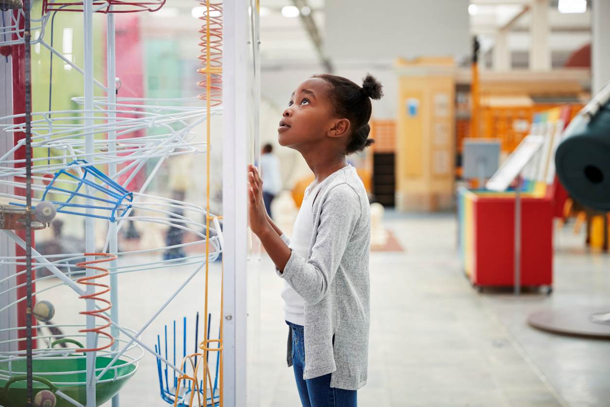 Young girl looking at an interactive exhibit at a museum.