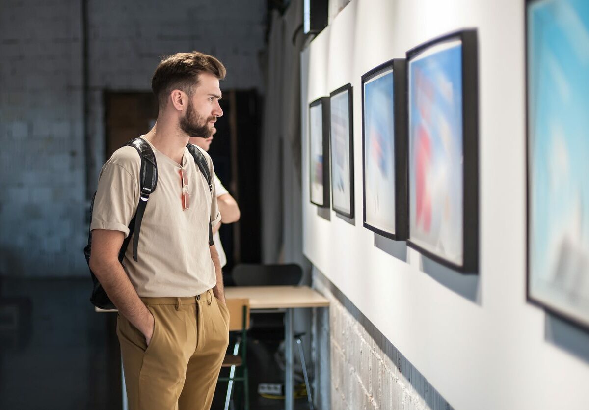Young man looking through an art gallery at a museum.