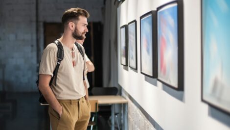 Young man looking through an art gallery at a museum.