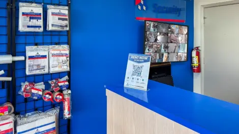 Office area with QR code and wall of storage supplies, move/packing supplies in Dallas Texas Devon Self Storage - Plantation Road