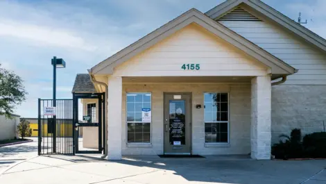 Storage facility in Pasadena, Texas. White building with stone walls.. Devon Self Storage Fairway Plaza