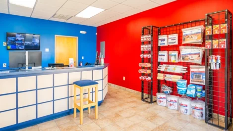 Office area with moving, packing supplies, plus security footage on the wall in Greensboro, NC, at Devon Self Storage - Hilltop Road
