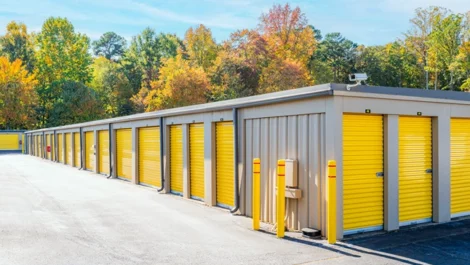 Angle view of self storage units with drive up options, yellow doors and wide lanes for unloading in Greensboro, NC, at Devon Self Storage - Hilltop Road
