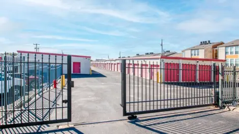 Gated, secure storage units with gate slightly open Devon Self Storage - Ingram Road in San Antonio, TX. View of drive up storage units.