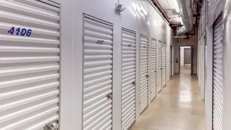 Hallway of small storage units with light, white doors in Hendersonville, TN, at Devon Self Storage - Shackle Island