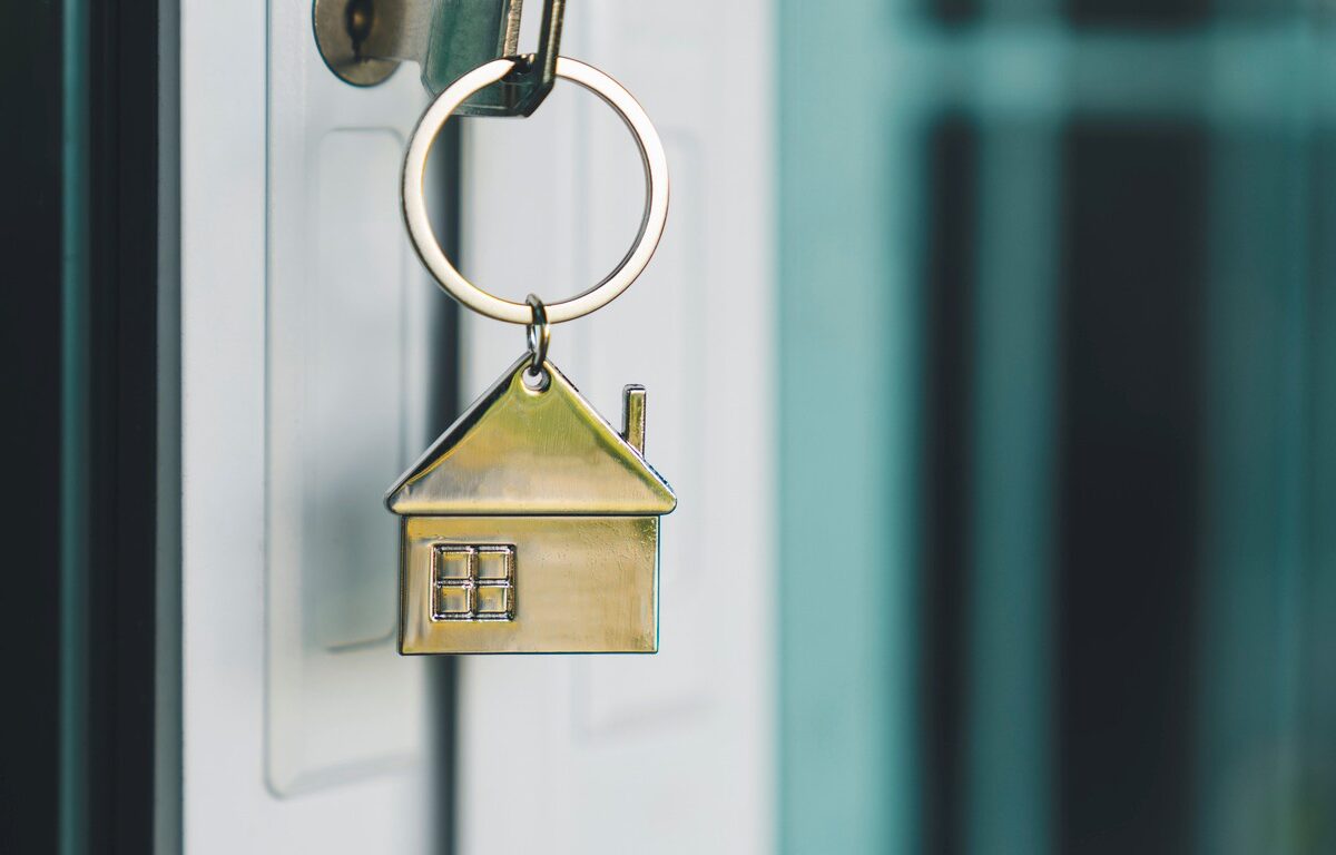 A golden key sitting in the door of someone’s newly bought home.