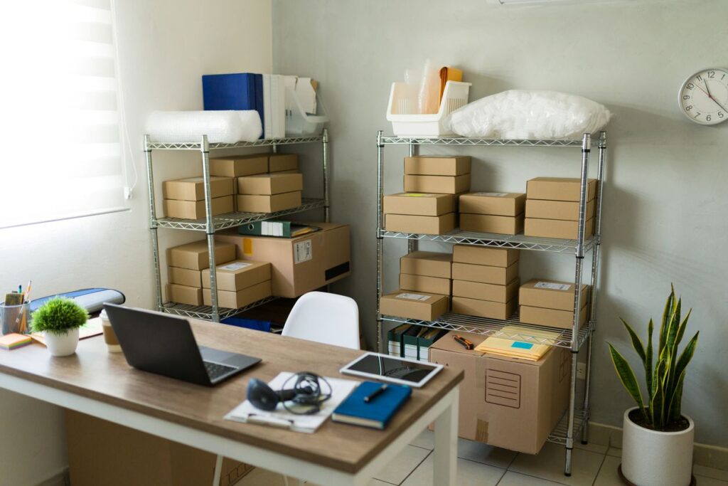 An office that is crowded with boxes of business supplies. 